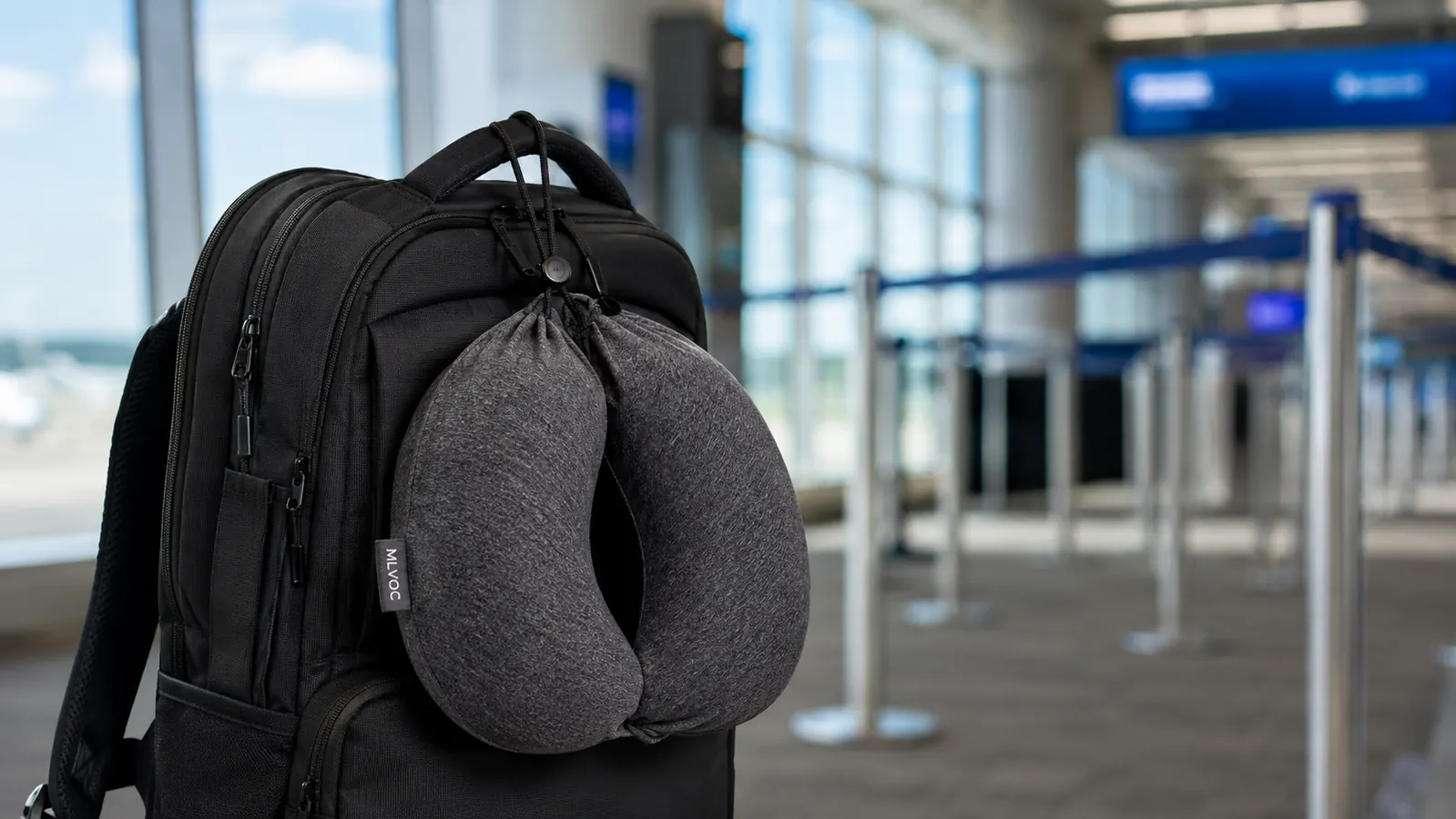 Neck pillow compressed and clipped to the outside of a carry-on backpack before boarding