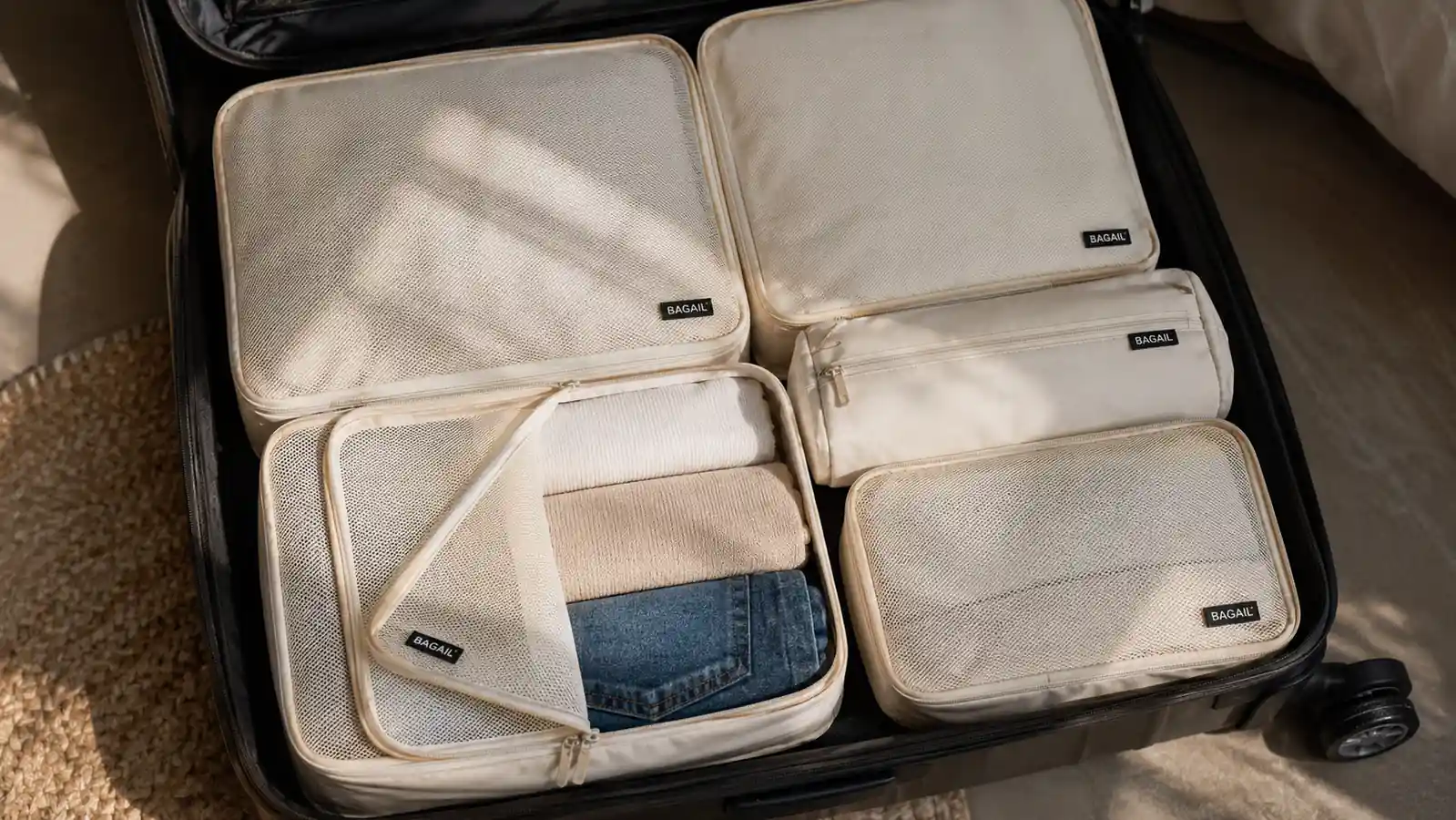 Open carry-on suitcase with multiple packing cubes arranged neatly by category, labeled by color
